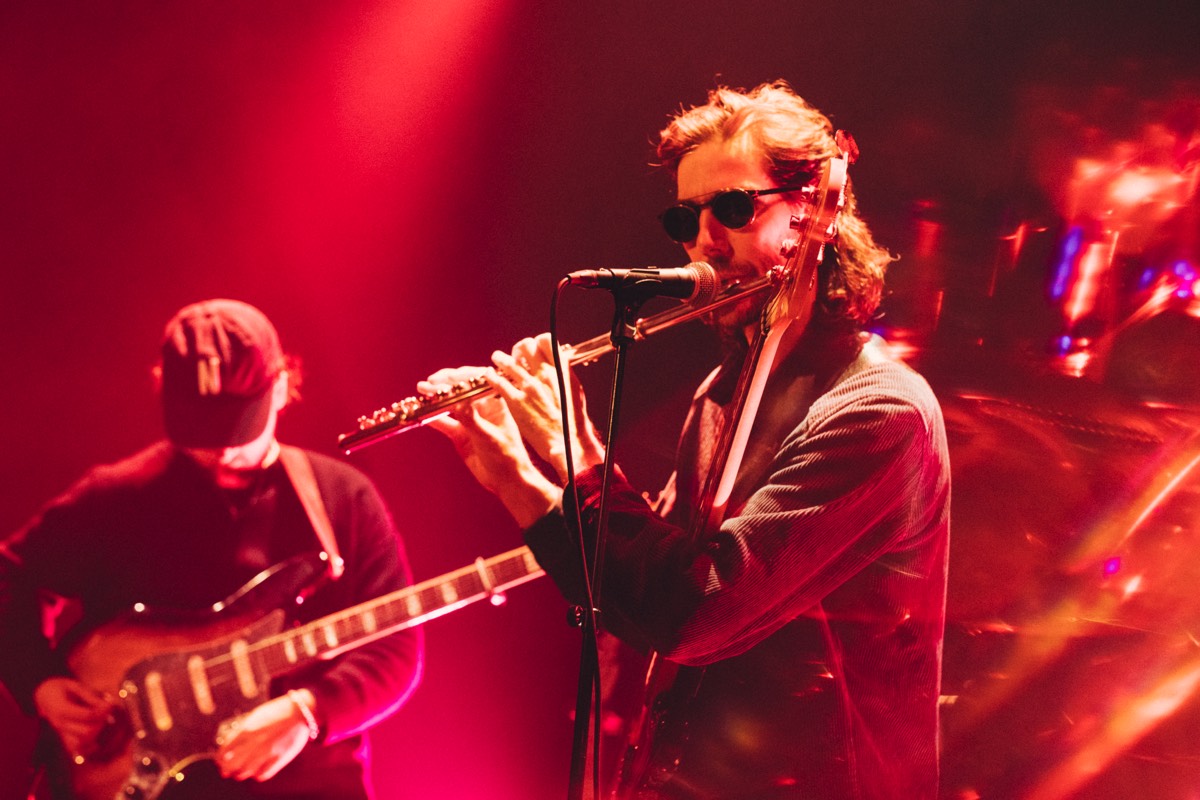 Florian Egli playing flute on stage in red light